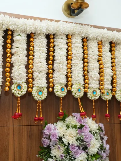 A close-up of the intricate 'thoranam' or floral garland adorning the top of the door for a housewarming.