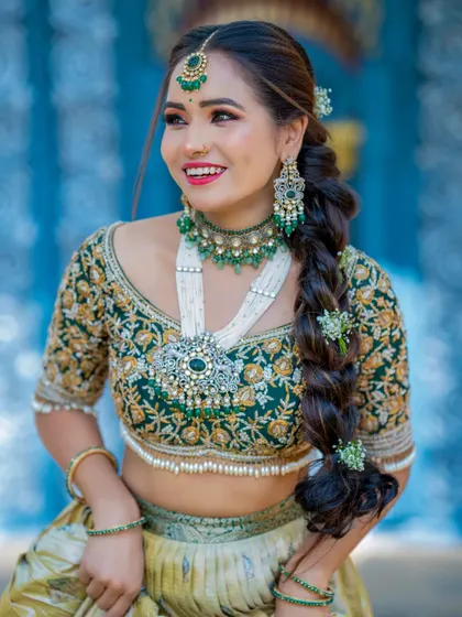 This bride looks radiant in a green embroidered lehenga. The look is completed with a beautiful braided hairstyle decorated with fresh flowers and statement silver and pearl jewelry.