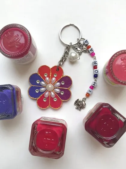 This personalised keychain is a burst of colour. It features a hand painted flower design, pearl details, and name beads, making it a truly unique and special gift for someone.