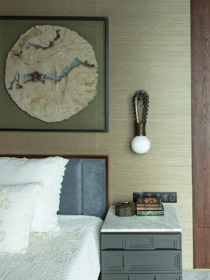 The younger daughter's bedroom features a wall clad in cork sheet, ready to be a canvas for her own creations. The room is adorned with art by Gopa Roy and a captivating installation made from natural fibers.