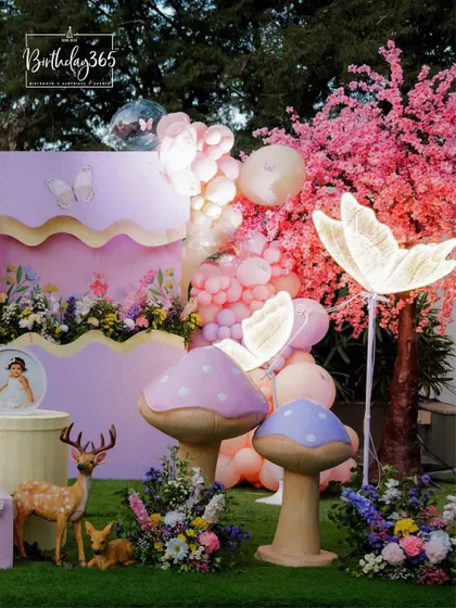 More details from our enchanted fairy party, showing the glowing butterfly lights, pink cherry blossom trees, and whimsical mushroom props.