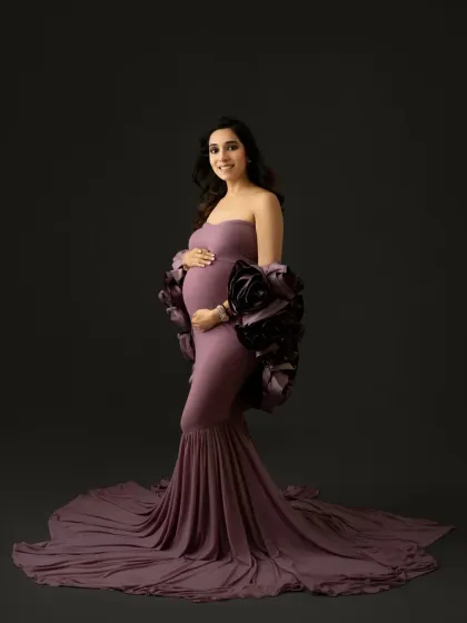 A direct, smiling portrait that radiates joy. Even in a high fashion gown, your personality can shine through. This is a perfect example of a glamorous yet warm maternity photo.