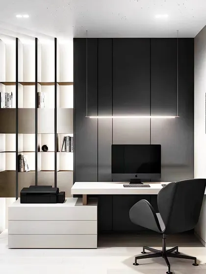 A sophisticated home office with a minimalist black and white theme. The design features a sleek, floating desk, a dark panelled accent wall, and a dramatic linear suspension light.