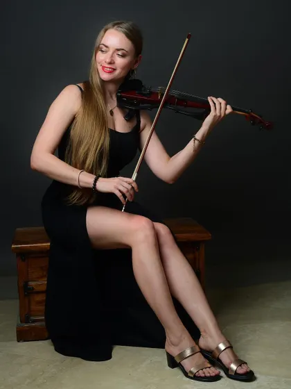 A full-length seated portrait of the musician. This pose is elegant and classic, showcasing both the artist and her instrument beautifully.