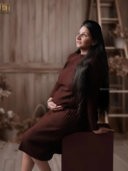 A hopeful, upward glance in a modern knit dress, set against a rustic wooden studio background.