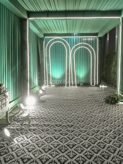 An interior view of the modern teal entrance tunnel, showing the repeating illuminated arches that create a futuristic and visually engaging path for guests.