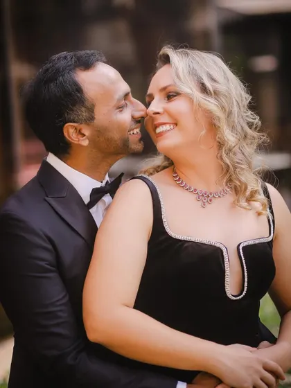 A joyful and intimate pre-wedding portrait. The couple's bright smiles and close embrace create a photo that is full of warmth and happiness.