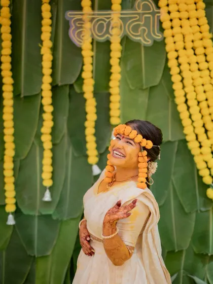 A joyful, candid shot of the bride laughing during her Haldi ceremony, her happiness is infectious.
