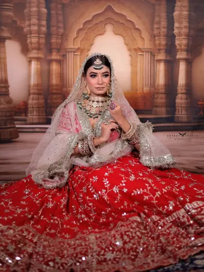 Another seated portrait, this time with the bride looking directly at the camera. The intricate silver work on her red lehenga is captured in stunning detail.