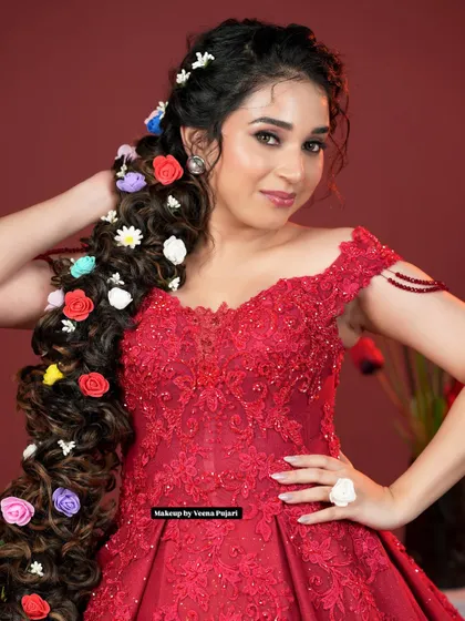 A whimsical and dramatic hairstyle for a reception or photoshoot. This extra-long braid is adorned with colorful flowers, creating a stunning, fairytale-inspired look.