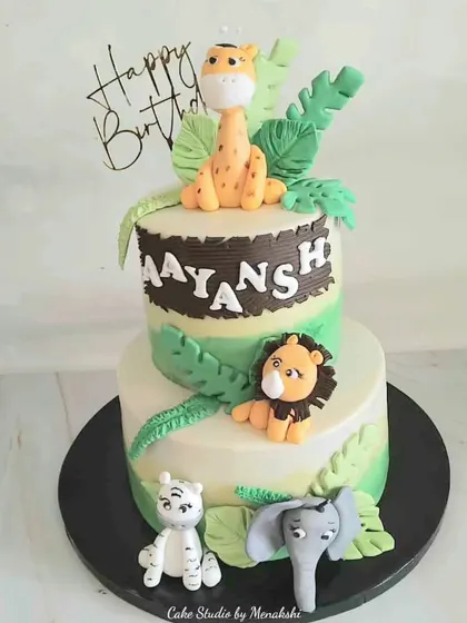 A fun, two-tier jungle adventure cake made for a toddler's birthday. I loved crafting the cute, friendly lion, giraffe, tiger, and elephant to create a delightful scene for the little one's big day.