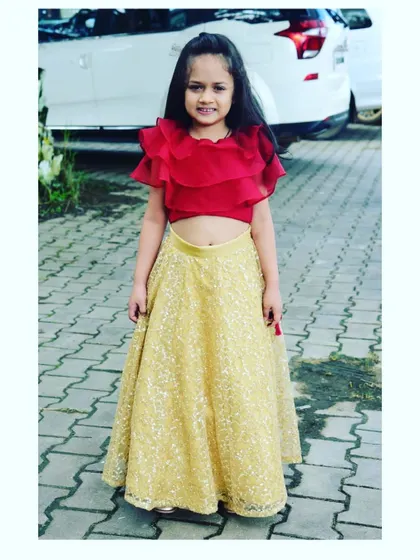 Another shot of little Bianca looking precious in her gold and red lehenga set, ready for a wedding celebration.