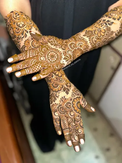 A lovely crossed-hands pose showing off the intricate floral design. This is a great option for an engagement or any pre-wedding celebration.