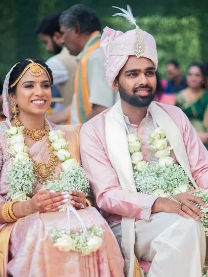 A beautiful candid moment of the couple during their wedding ceremony, dressed in elegant pastel outfits that complement the soft, romantic decor.