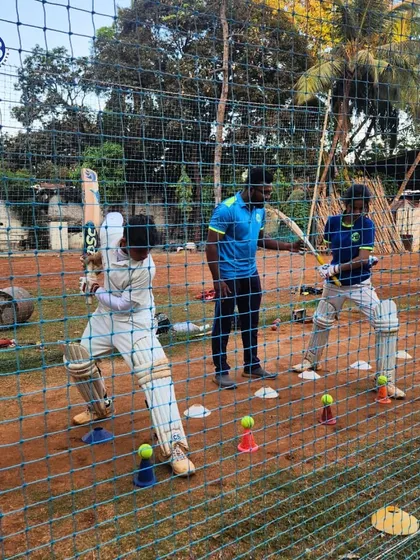 A player practices his batting form in the nets, surrounded by drill cones. We use various training aids to create specific scenarios and improve our players' footwork and shot selection.