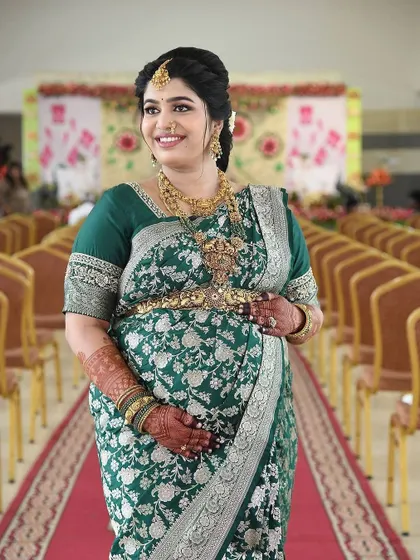 A beautiful mom-to-be at her Seemantha ceremony. The rich, dark stain of her mehendi stands out against her gorgeous green saree, completing her traditional look.