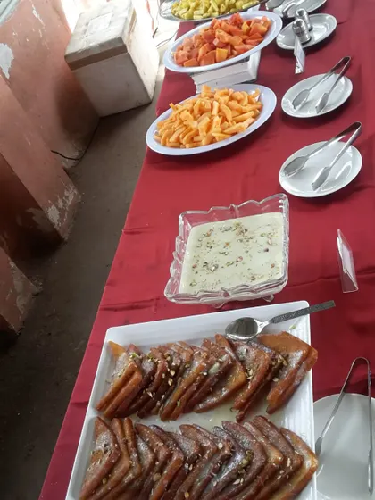 A delightful spread of traditional Indian sweets and snacks. This table features Shahi Tukda, Rabri, Jalebi, and fresh-cut fruits, perfect for festive occasions and family gatherings.