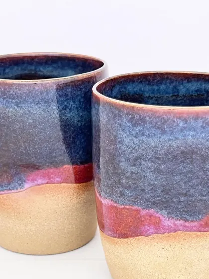 A close-up of the Celestial Dunes mugs, where you can see the beautiful interaction between the red and blue glazes.