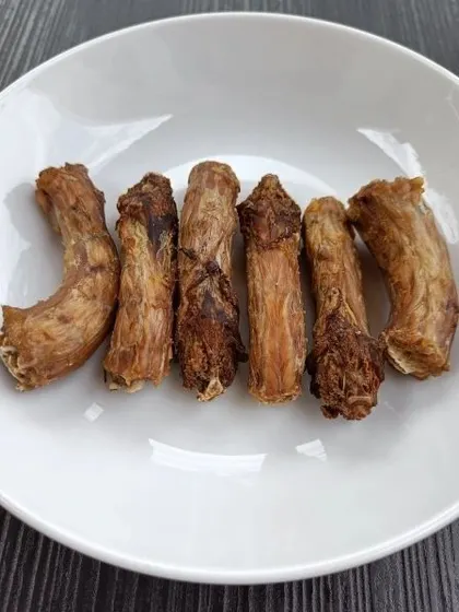 A bowl full of our baked chicken neck chews. These are a fantastic addition to your dog's snack rotation, offering both a tasty reward and dental benefits.