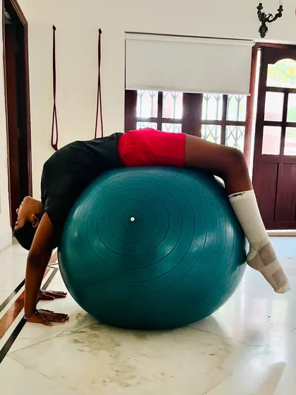 This student demonstrates an advanced backbend over a stability ball, showing excellent spinal flexibility and control. We focus on progressive training to achieve such poses.