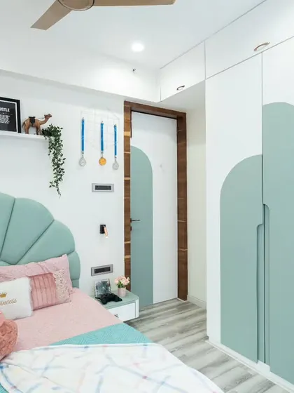 This shot captures the entire room, from the bed to the study area and the arched doorway, all tied together with a consistent color scheme and design language.