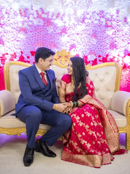 The couple shares a moment on the reception stage, dressed in elegant evening wear.
