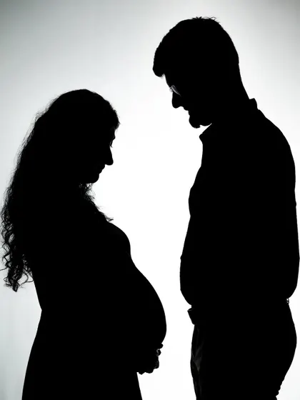 A striking silhouette of an expecting couple. The clean lines and contrast created in the studio make for a powerful and modern piece of art to remember this special time.