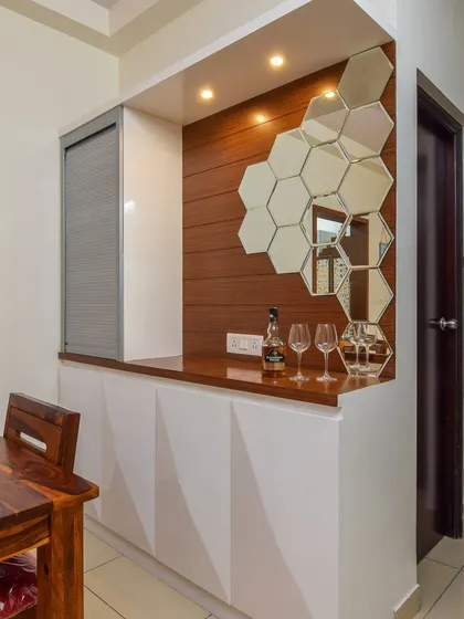 The full crockery and bar unit, featuring geometric-patterned white cabinet doors and a rich wood-panelled backsplash. It's a perfect example of a stylish and functional dining room storage solution.