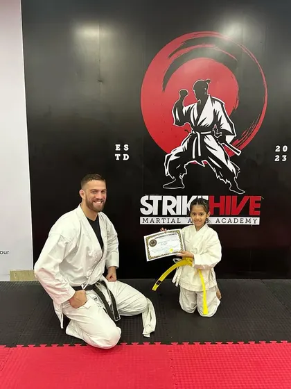 Another proud moment as a young girl receives her yellow belt. Our coaches are dedicated to mentoring the next generation of martial artists.