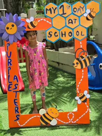 A beautiful smile from a student in our 'First Day' photo frame, surrounded by cheerful bees and flowers.