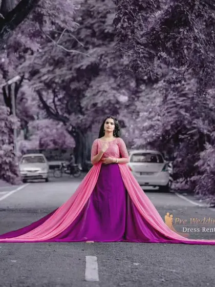 The full length of the pink and purple dual-tone trail gown is displayed here, stretching across a road for a unique and impactful shot.