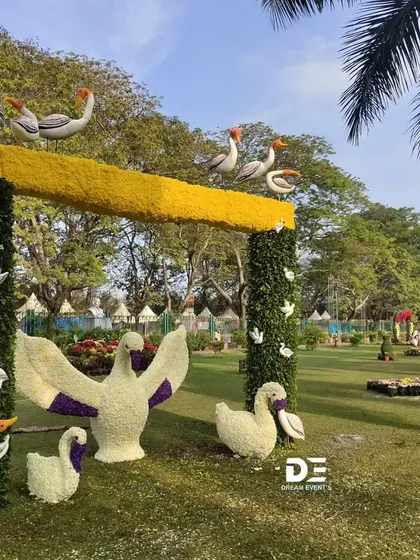 This whimsical archway features a flock of swans and other birds sculpted from white flowers, appearing to take flight from the greenery. It was designed to be an interactive and imaginative piece that delighted both children and adults.