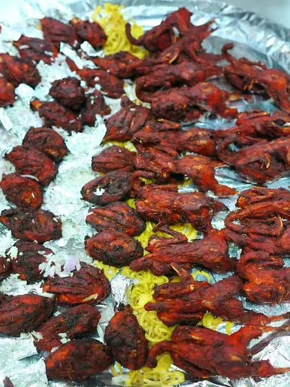 A platter of delicious fried Kaadai (quail), garnished with onions. This is a unique starter that will impress your guests.