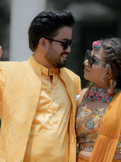 A cool, candid shot of Nikhil and Srishti at their Haldi, with a selective color effect that makes their yellow outfits pop against a monochrome background.
