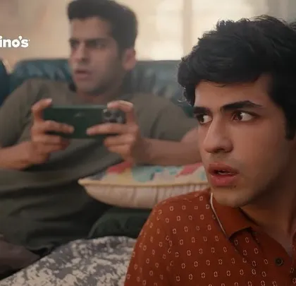 An expressive shot capturing the excitement of a gaming moment in the Domino's ad. The wardrobe is kept simple to keep the focus on the actors' reactions and the pizza.