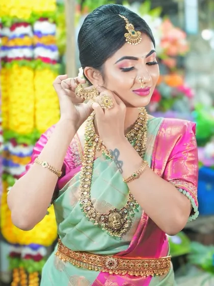 This bride looks absolutely radiant. We chose a layered antique gold necklace set to go with her mint green and pink silk saree, creating a beautiful contrast and a memorable look for her special day.