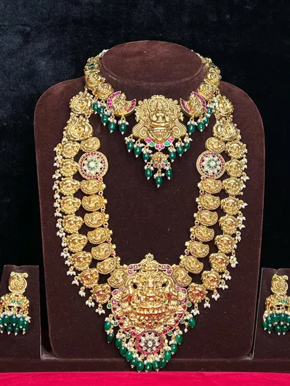 A complete Kasu Mala set with a matching choker and earrings. The green beads add a fresh and vibrant touch to the traditional design.