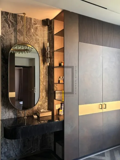 Here you can see how the wardrobe integrates with a side vanity that includes open shelving. This provides easy access to everyday items and a space for display, lit by elegant wall sconces.