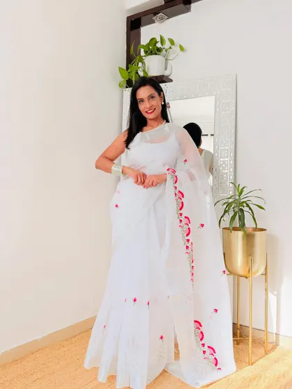 A classic white Kota Doria saree with beautiful red floral embroidery. This is a very graceful and timeless piece, perfect for any special occasion.