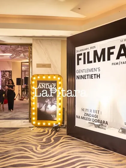 The entrance area featuring a giant, custom "Filmfare" magazine cover photo booth. Guests could pose as cover stars, creating a fun, interactive experience.