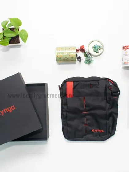 A welcome kit for Zynga featuring a custom sling bag, a mug, and a scented candle, all presented in a sleek black branded box. It's a great example of a simple yet thoughtful gift set.