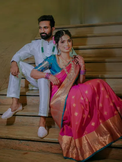 A stylish portrait of the couple seated on a staircase, showcasing their modern yet traditional engagement look.