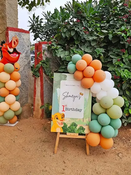 A personalized welcome sign for a Lion King themed first birthday, complete with character cutouts and a matching balloon arrangement.