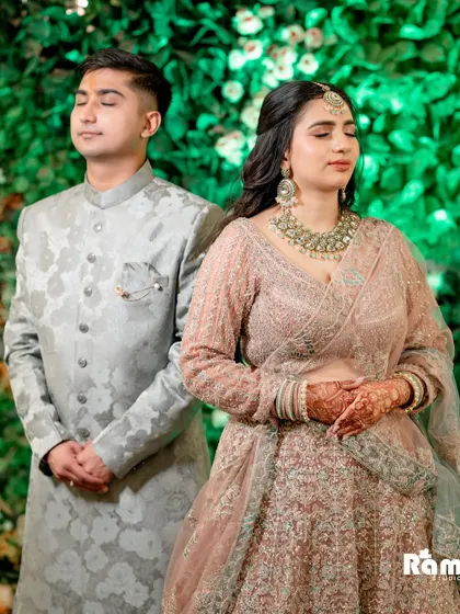 A serene portrait of the couple with their eyes closed, standing against a lush green backdrop. This image captures a moment of quiet connection and peace.