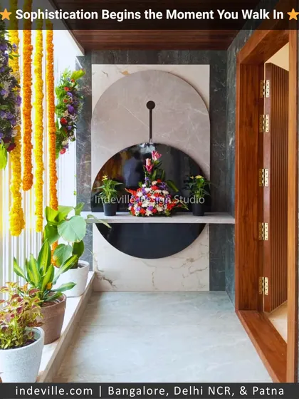 A home's story begins at the entrance. I designed this entryway with a modern marble and mirror feature, complemented by lush potted plants and traditional flower garlands for a sophisticated first impression.