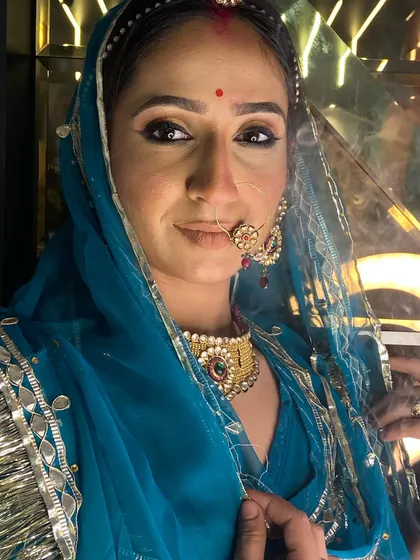 A detailed close-up of the Rajasthani bridal makeup, showing the precision in the eye makeup and the placement of the bindi and maang tikka.