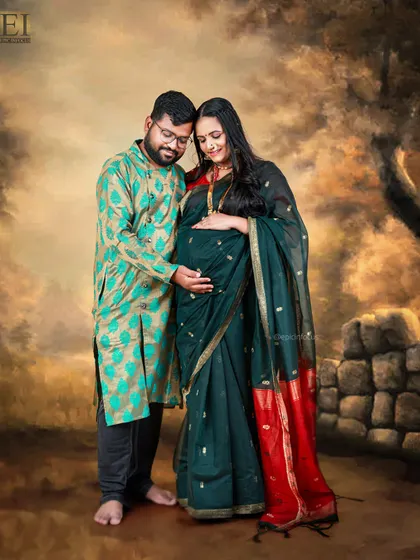 A couple's portrait with a painted, rustic backdrop. Their traditional outfits create a timeless, artistic feel.