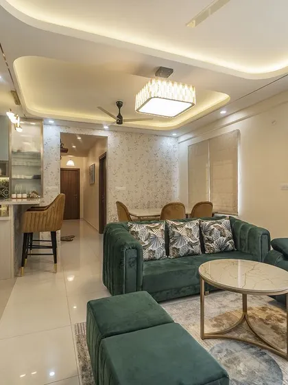 The emerald green sofa and recliner provide a luxurious and comfortable seating arrangement. The neutral background allows the vibrant color of the furniture to truly stand out.