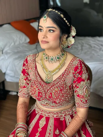This bride is poetry in red. The makeup is soft and flawless, blending tradition with freshness. Her skin is luminous, and her eyes are subtly defined to create a hint of bridal boldness.