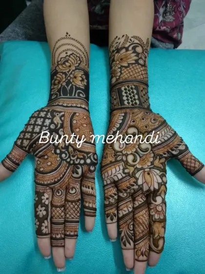 This design combines bold floral work with delicate, dense patterns. The contrast between the filled and empty spaces gives the mehandi a beautiful depth.